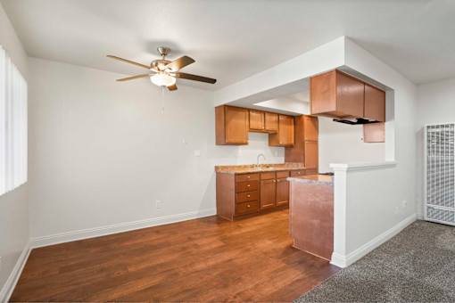 A kitchen with wooden cabinets and a ceiling fan.