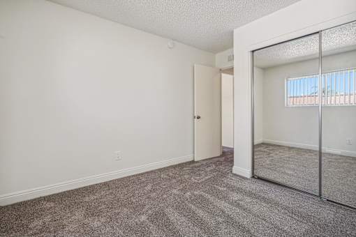 A room with a carpeted floor and a mirror on the wall.