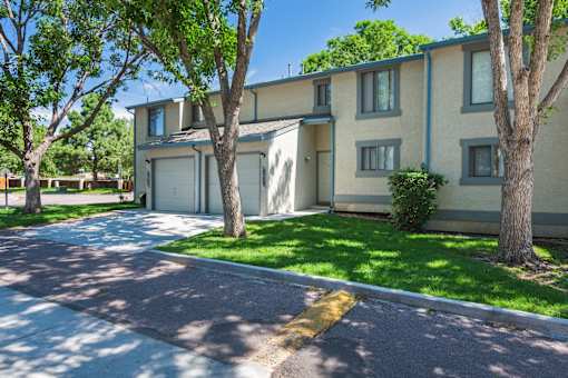 A sunny day at a residential area with apartment buildings and green trees.