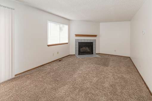 A room with a fireplace and carpeted floor.