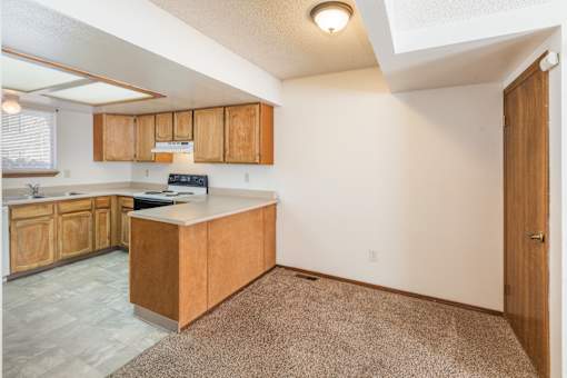 A kitchen with wooden cabinets and a white countertop.