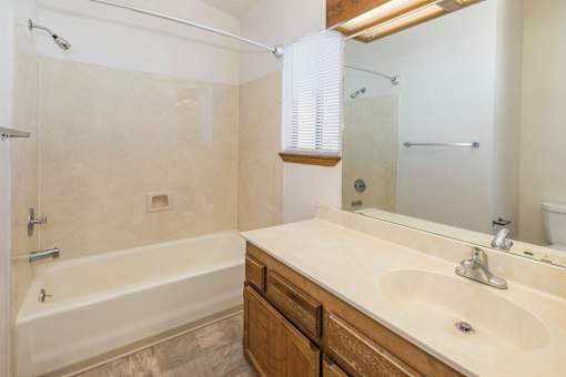 A bathroom with a white tub and sink.