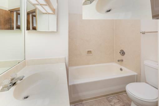 A white bathroom with a sink, toilet and bathtub.