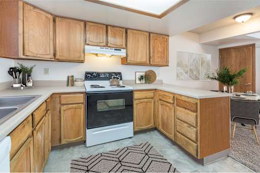 A kitchen with wooden cabinets and a white oven.