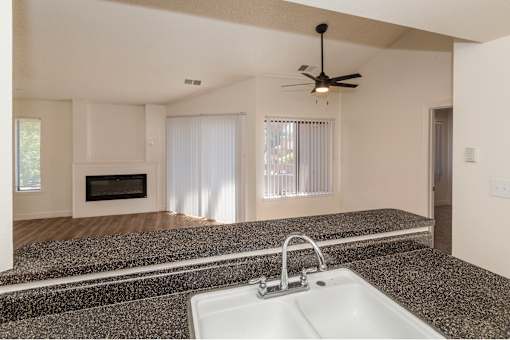 A modern kitchen with granite countertops and a white sink.