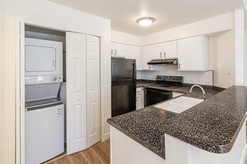 A kitchen with black appliances and white cabinets.