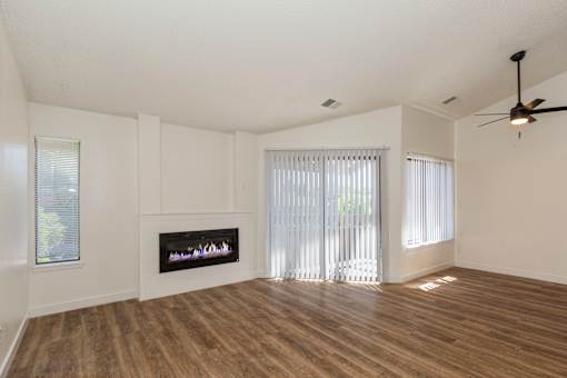A room with a fireplace and a ceiling fan.