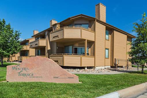 A large house with a sign in front that says Western Terrace Apartments.