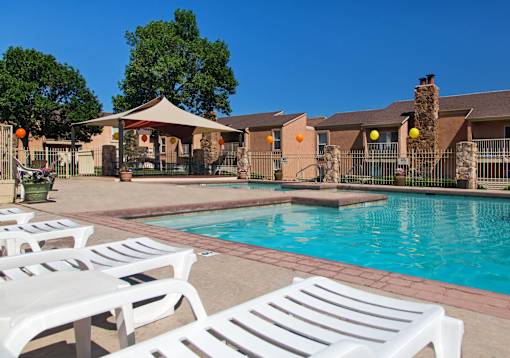 A pool surrounded by white lounge chairs.