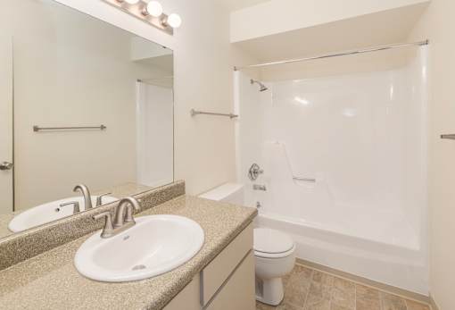 A bathroom with a sink, toilet, and bathtub.