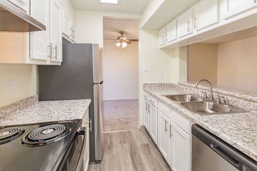 A kitchen with a black refrigerator, stove, and dishwasher.