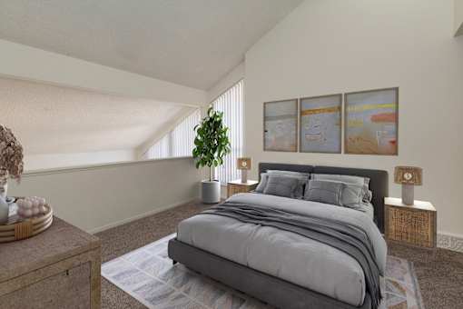 A bedroom with a large bed and a potted plant.