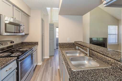 A kitchen with granite countertops and stainless steel appliances.