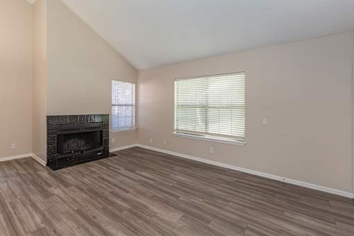 A room with a fireplace and wood flooring.