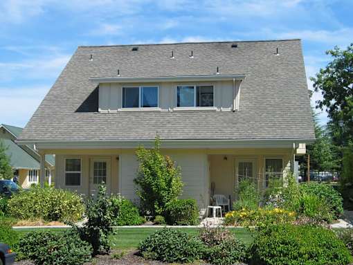 A house with a grey roof and a yellow front.