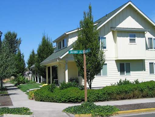 A white building with a green sign that says Jacobs.
