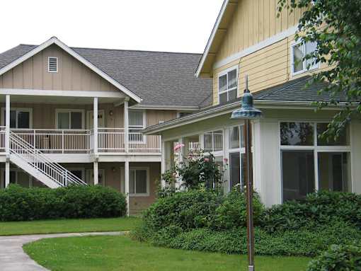 A building with a yellow and beige exterior with a white trim.