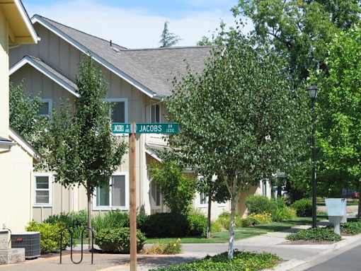 A street sign for Jacobs street is in front of a house.