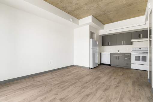 A kitchen with white appliances and wooden floors.