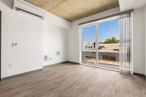 A room with a sliding glass door leading to a balcony.
