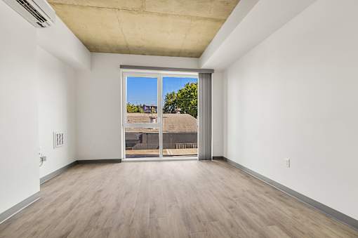 A room with a sliding glass door leading to a balcony.