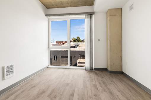 A room with a sliding door leading to a balcony.