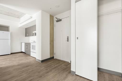 A kitchen with white appliances and a white door.