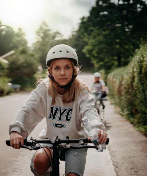 a young girl riding a bike down a street