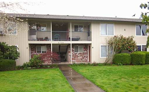 Apartment building with a green lawn in front.