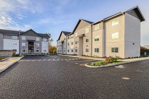 A parking lot in front of a building with a clear blue sky.