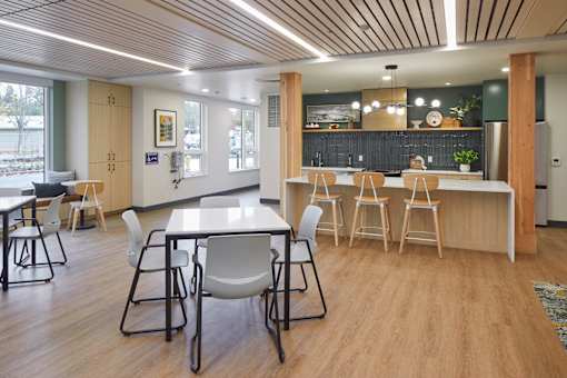 A modern dining area with a long table and chairs.