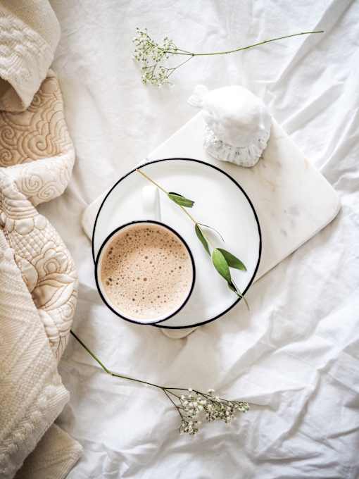 a cup of coffee with a flower on a plate