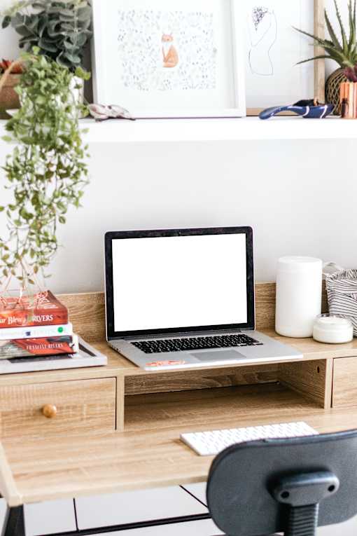 a desk with a laptop with a white screen