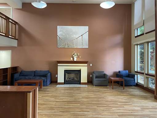 A living room with a fireplace and a painting on the wall.