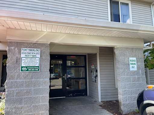 A sign on a pillar outside a building states that the parking is for permit holders only.