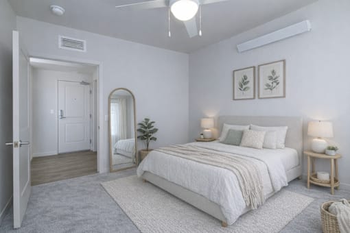 A bedroom with a large bed, a mirror, and two lamps.
