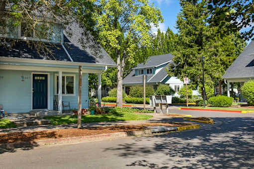 A blue house with a white porch and a green door.