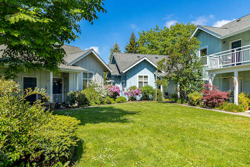 A sunny day in a suburban neighborhood with a well-kept lawn and colorful flowers.