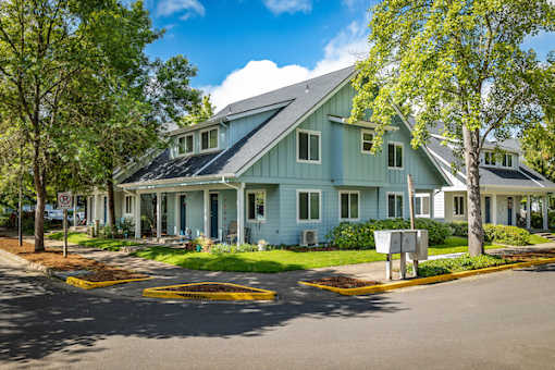A blue house with a white fence and a mailbox in front.