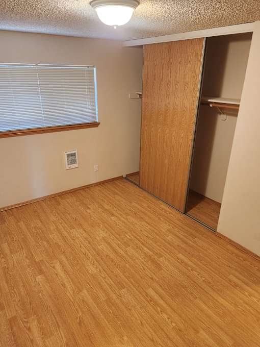 A room with a wooden floor and a sliding door.