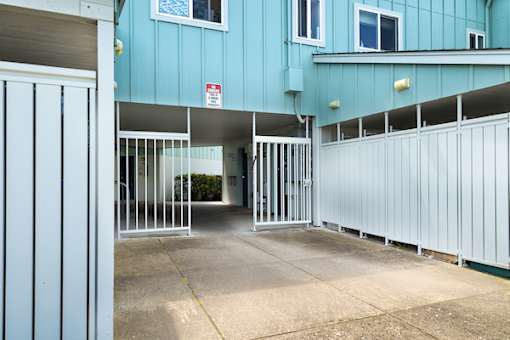 A blue building with a white gate in front.