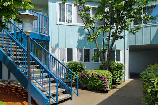 A blue staircase with a lamp on top leads to a white door.