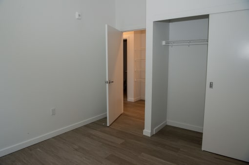 a bedroom with a closet and a door into a hallway
