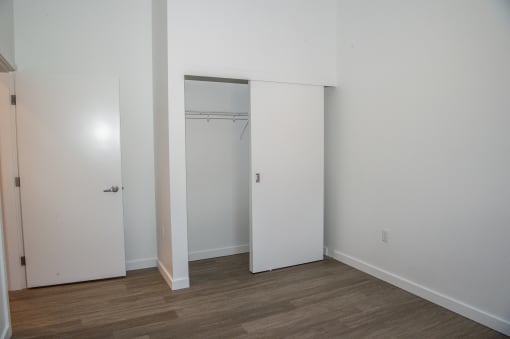 an empty room with white walls and a closet