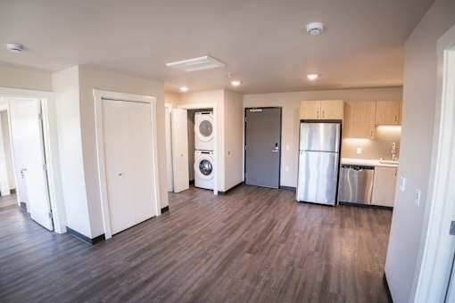 A kitchen area with a refrigerator, dishwasher, and washer.