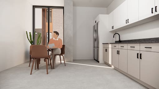 A man is sitting at a table in a modern kitchen.