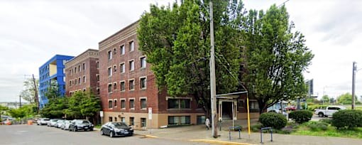 A parking lot with cars and a building in the background.