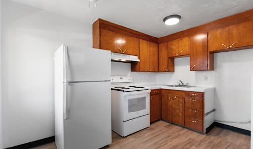 A kitchen with wooden cabinets and white appliances.
