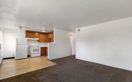 A kitchen with white appliances and wooden cabinets is visible.