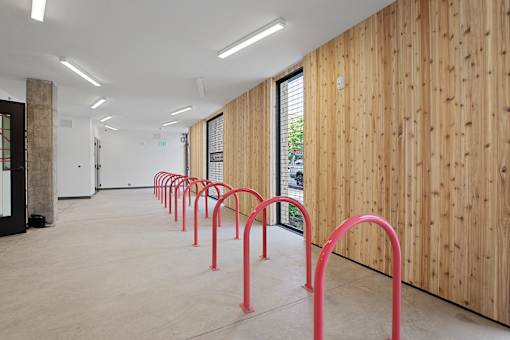 A long hallway with red handles on the wall.